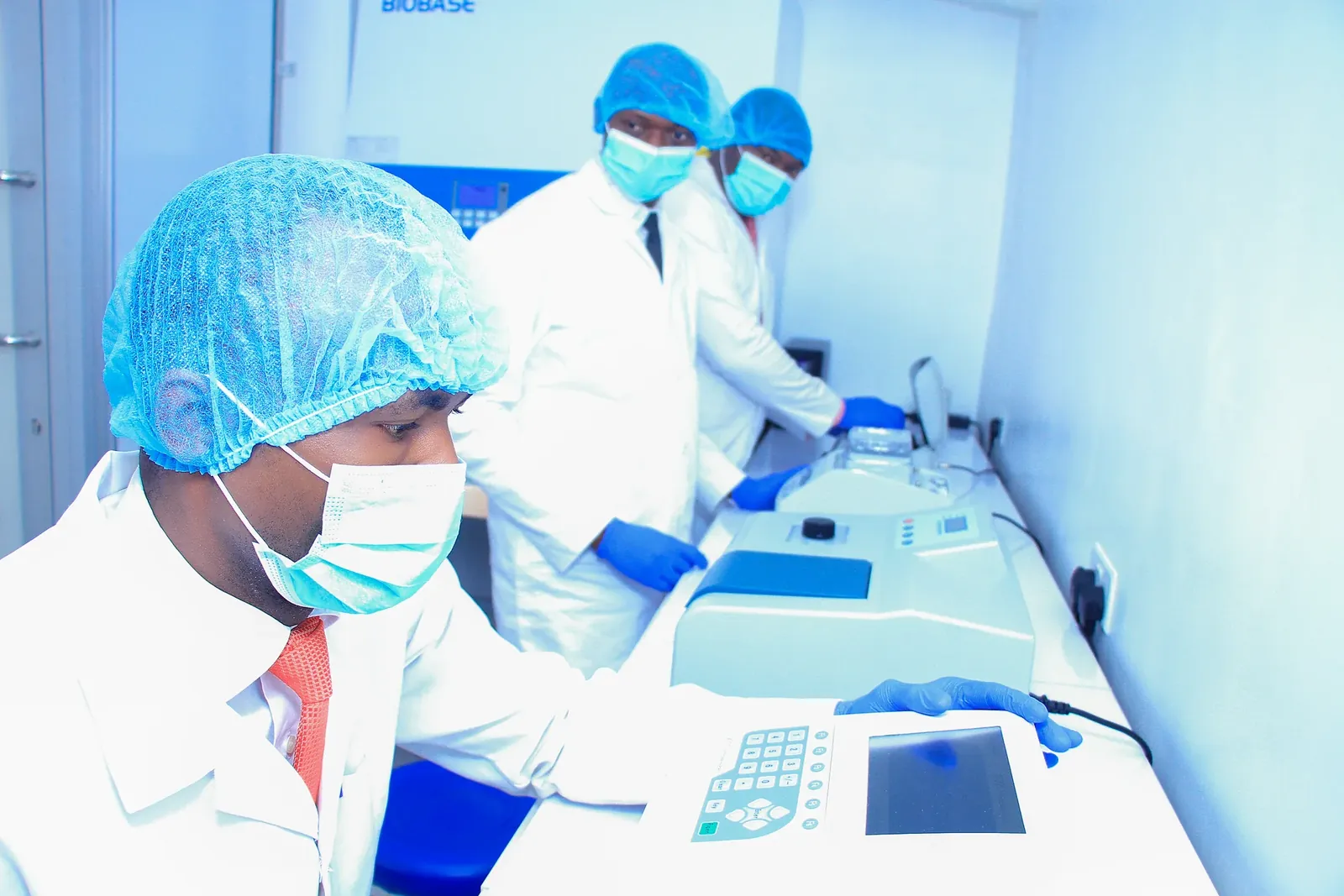 Everight scientists in full PPE operating real-time PCR thermocyclers inside the Level-3 biosafety molecular laboratory